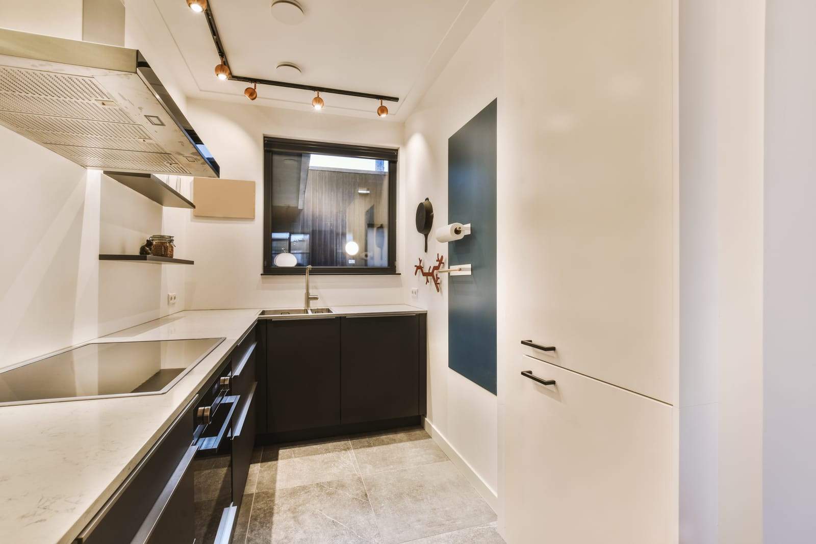 Kitchen with black and white counters and a window